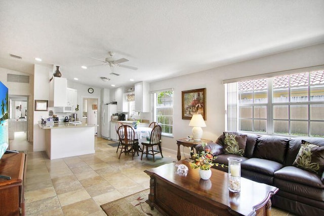 living area with a ceiling fan, recessed lighting, visible vents, and vaulted ceiling