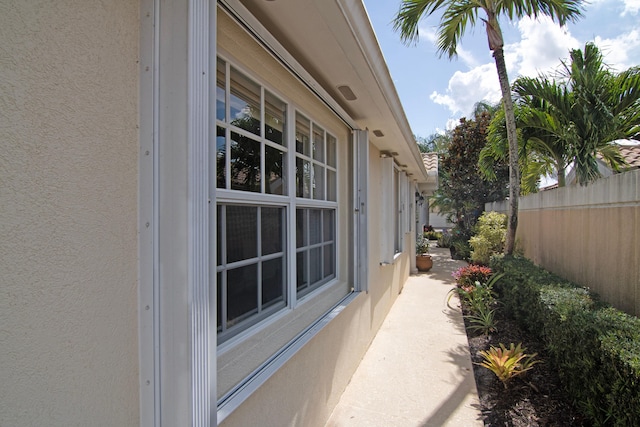 view of home's exterior with fence and stucco siding