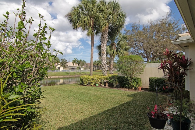 view of yard with a water view and fence