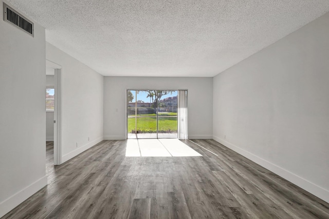 unfurnished room featuring dark hardwood / wood-style flooring and a textured ceiling