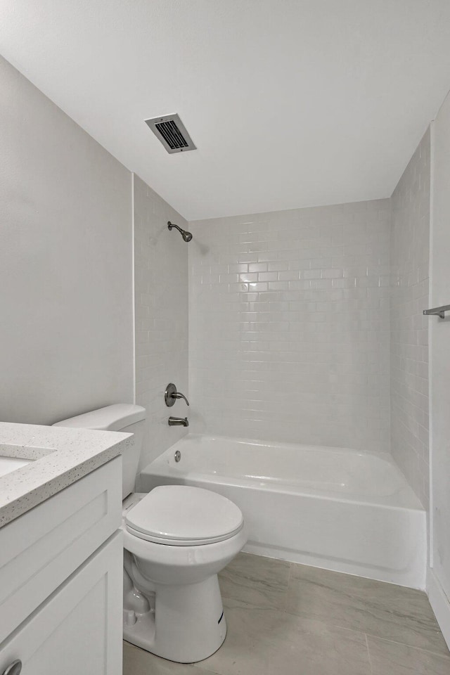 full bathroom with vanity, tiled shower / bath combo, and toilet