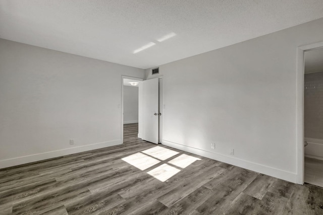 unfurnished bedroom featuring dark hardwood / wood-style floors and a textured ceiling