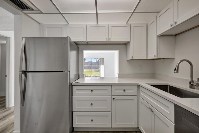 kitchen featuring white cabinetry, sink, stainless steel fridge, and dishwasher