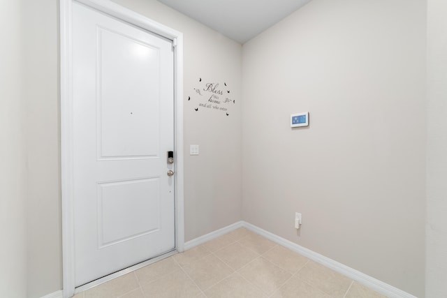 doorway to outside featuring baseboards and light tile patterned floors