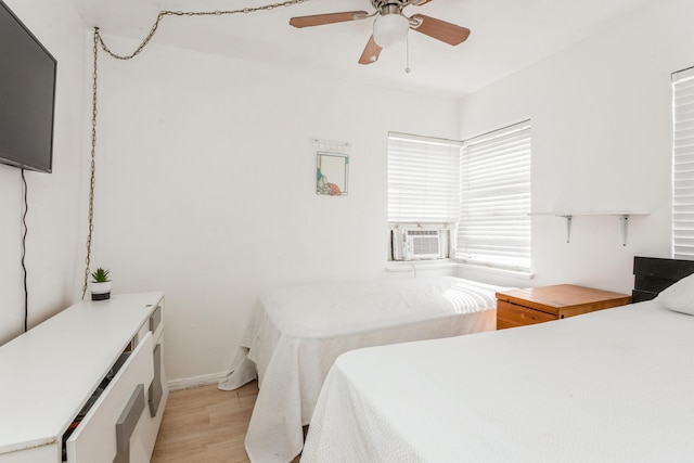 bedroom featuring cooling unit, light wood-type flooring, and ceiling fan