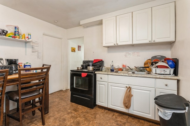 kitchen with sink, black / electric stove, and white cabinets