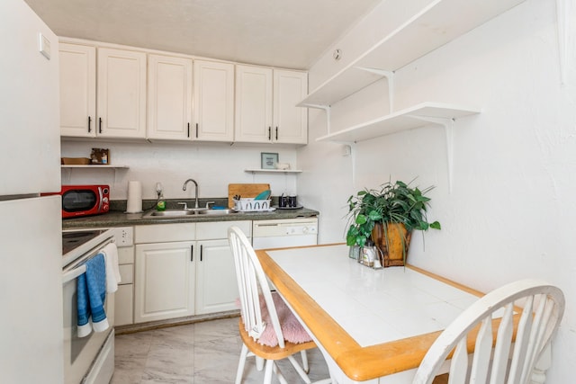 kitchen with white appliances, sink, white cabinets, and tile counters