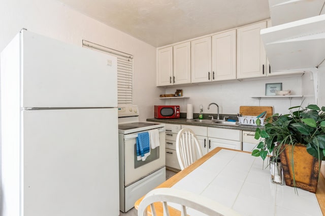 kitchen featuring sink, white appliances, tile countertops, and white cabinets