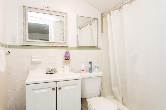 bathroom with lofted ceiling, vanity, tile walls, and toilet