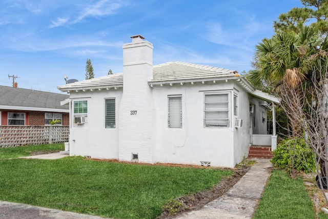 view of side of property featuring a lawn and cooling unit