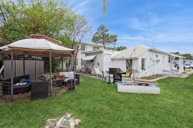 rear view of house with a lawn, a storage unit, and a gazebo