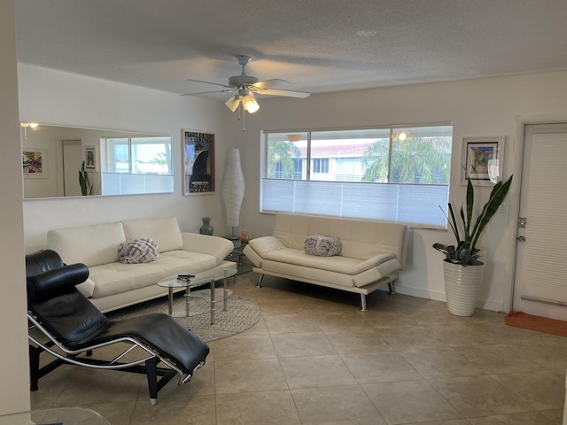 living room featuring ceiling fan, plenty of natural light, a textured ceiling, and light tile patterned flooring