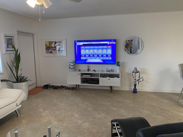 tiled living room with baseboards and a ceiling fan