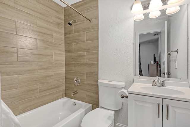full bathroom with vanity, tiled shower / bath combo, and toilet