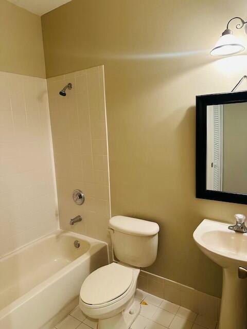 bathroom featuring toilet, shower / bath combination, baseboards, and tile patterned floors