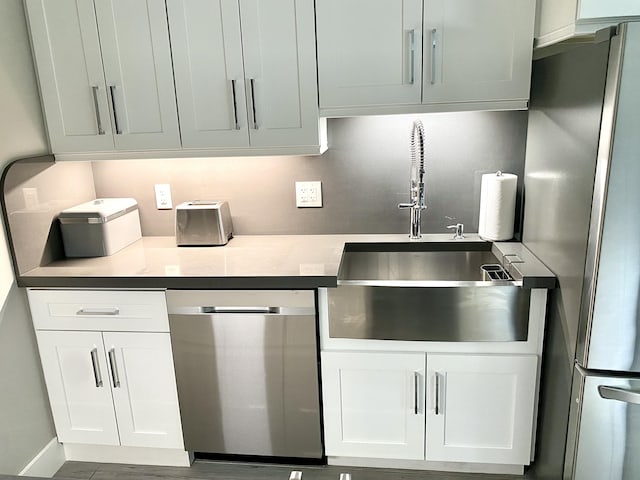 kitchen featuring appliances with stainless steel finishes, sink, and white cabinets