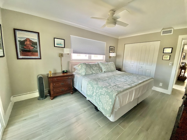 bedroom featuring ceiling fan, ornamental molding, and a closet