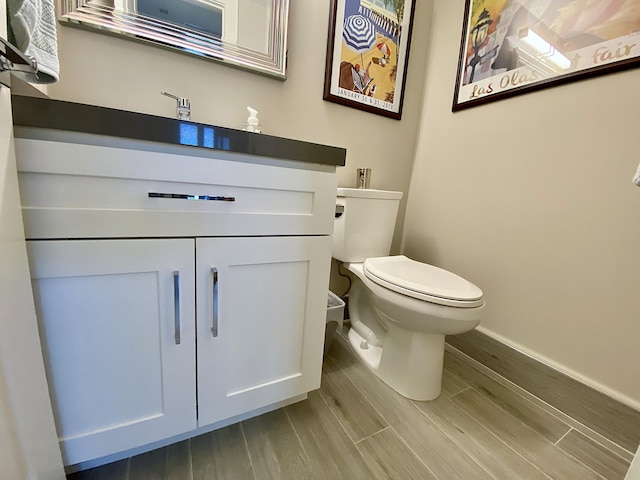 bathroom featuring hardwood / wood-style flooring, vanity, and toilet