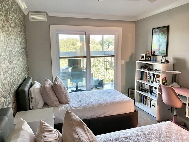 bedroom with hardwood / wood-style floors, crown molding, and access to outside