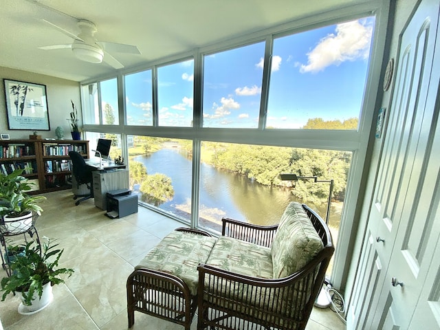 sunroom / solarium with a water view and ceiling fan