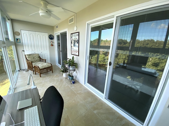 interior space with light tile patterned floors and ceiling fan