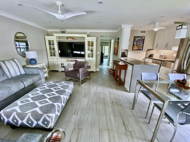 living room featuring ornamental molding, ceiling fan, and light hardwood / wood-style floors