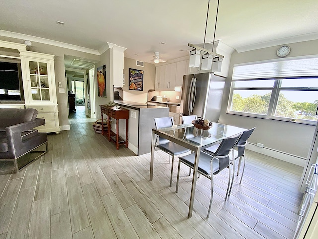 dining room with crown molding and light hardwood / wood-style flooring