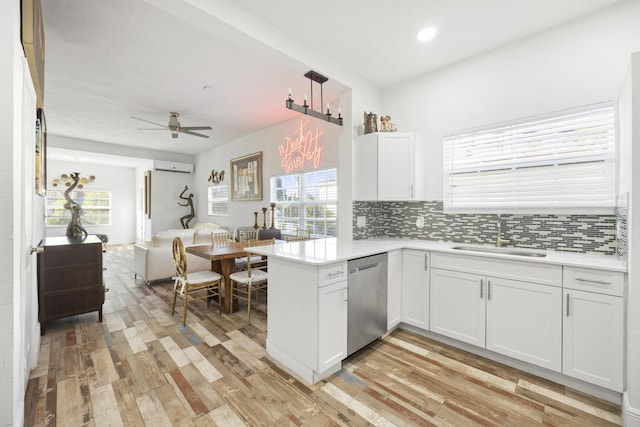 331 NW 1st Ave, Boynton Beach, FL 33435 - kitchen with an AC wall unit, white cabinetry, dishwasher, sink, and kitchen peninsula