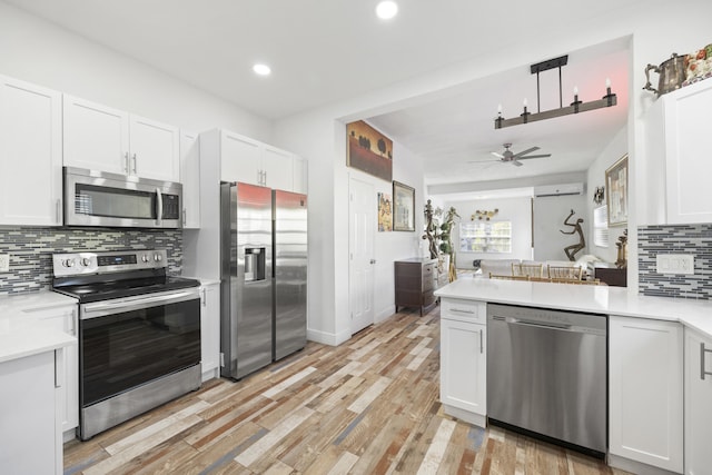 331 NW 1st Ave, Boynton Beach, FL 33435 - kitchen featuring white cabinetry, stainless steel appliances, light hardwood / wood-style flooring, and backsplash