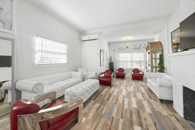 331 NW 1st Ave, Boynton Beach, FL 33435 - living room featuring lofted ceiling, a wall mounted air conditioner, a stone fireplace, and light hardwood / wood-style flooring
