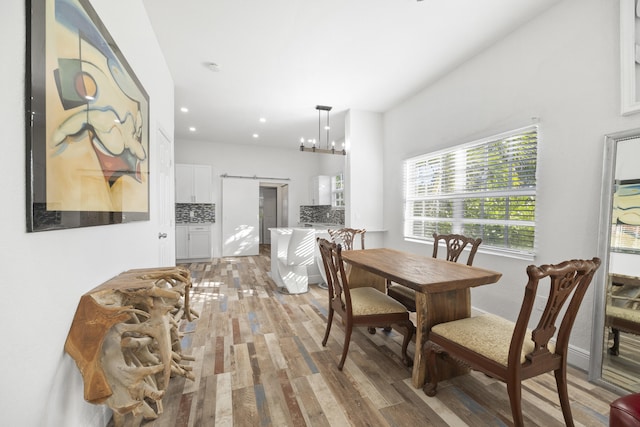 331 NW 1st Ave, Boynton Beach, FL 33435 - dining area with a notable chandelier, a barn door, and light wood-type flooring