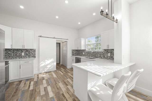 331 NW 1st Ave, Boynton Beach, FL 33435 - kitchen with sink, white cabinetry, kitchen peninsula, stainless steel dishwasher, and a barn door
