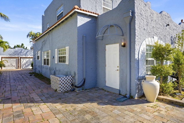 331 NW 1st Ave, Boynton Beach, FL 33435 - back of house featuring a garage and a patio area