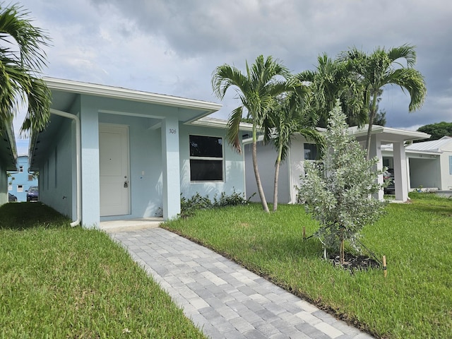 view of exterior entry with a lawn