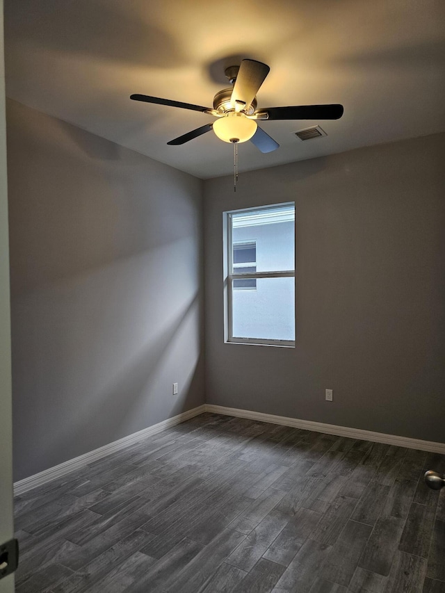 empty room with dark wood-type flooring and ceiling fan