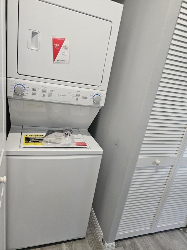 clothes washing area featuring stacked washer and dryer and light hardwood / wood-style floors