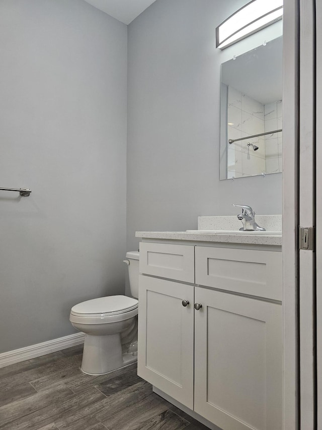 bathroom with vanity, hardwood / wood-style floors, a shower, and toilet