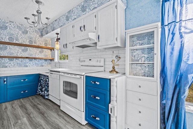 kitchen featuring open shelves, light countertops, white appliances, under cabinet range hood, and wallpapered walls