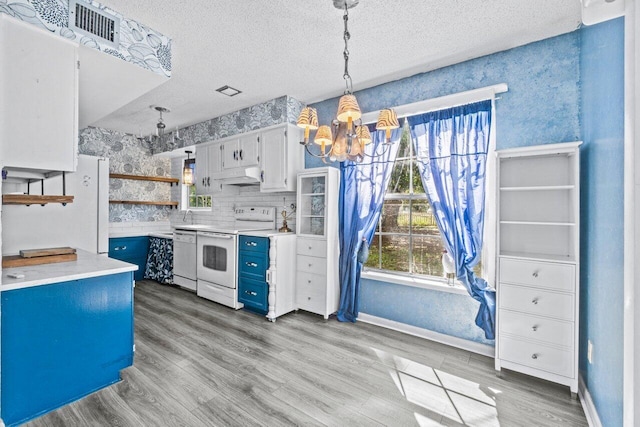 kitchen featuring white appliances, white cabinets, light countertops, open shelves, and pendant lighting