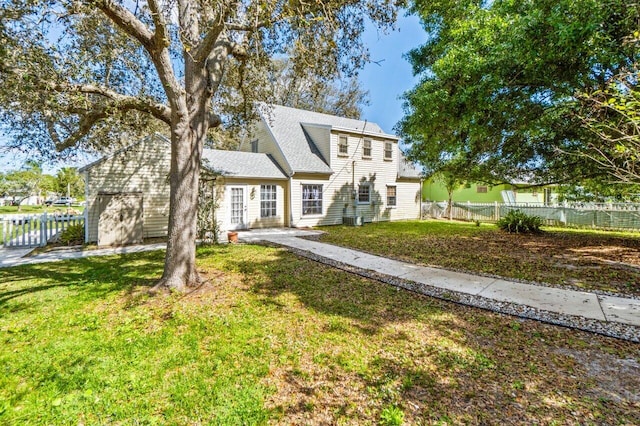 colonial inspired home with fence and a front yard