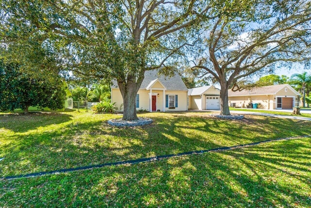 view of front of property featuring a garage, fence, and a front lawn