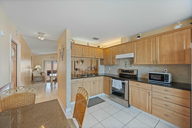 kitchen with lofted ceiling, sink, stainless steel electric range oven, light tile patterned floors, and decorative backsplash