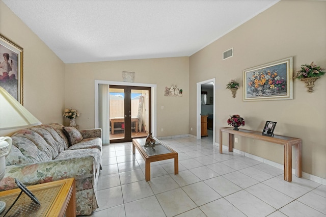 tiled living room with french doors, lofted ceiling, and a textured ceiling