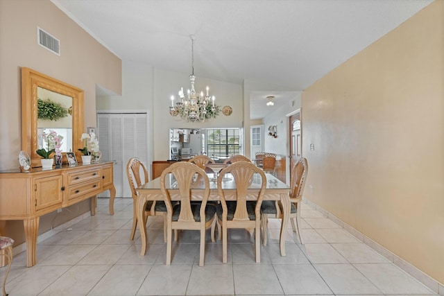 dining area featuring lofted ceiling, light tile patterned floors, and a chandelier