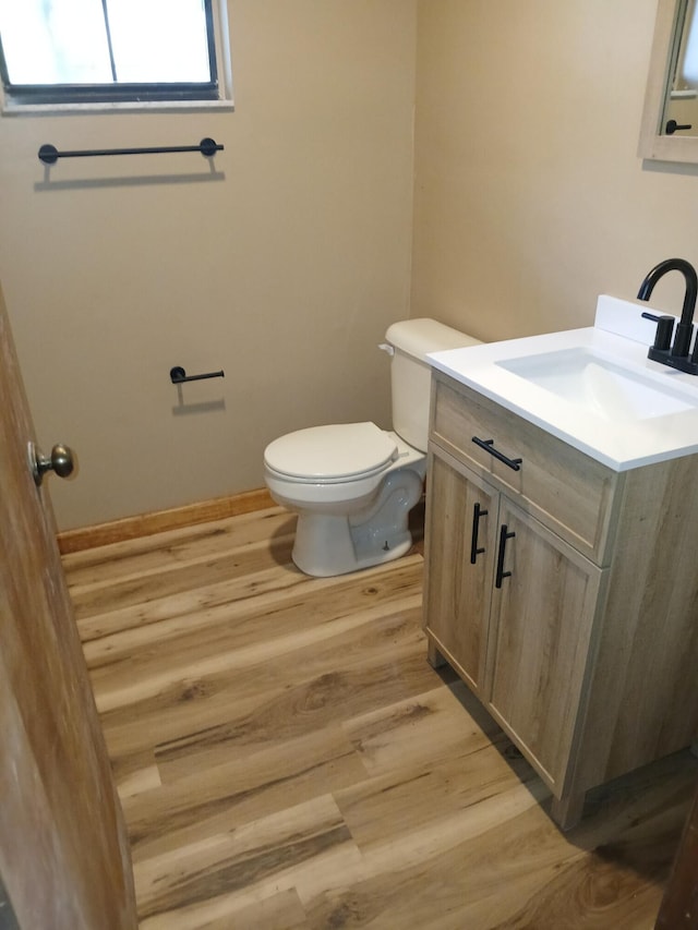 bathroom featuring vanity, wood-type flooring, and toilet