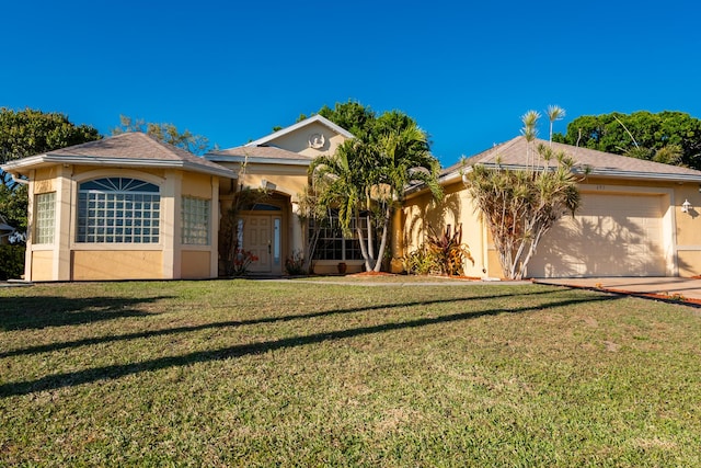 view of front facade with a front yard, an attached garage, and stucco siding