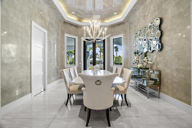 dining area featuring french doors, a tray ceiling, an inviting chandelier, and a high ceiling