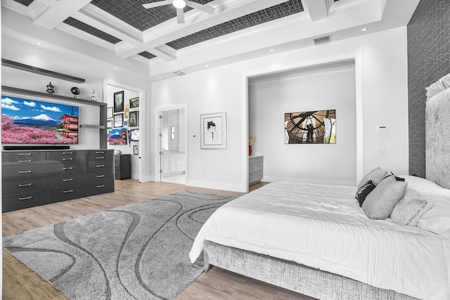 bedroom with beamed ceiling, connected bathroom, coffered ceiling, and hardwood / wood-style floors