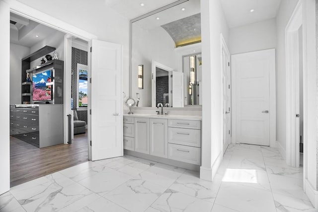 bathroom featuring a towering ceiling and vanity