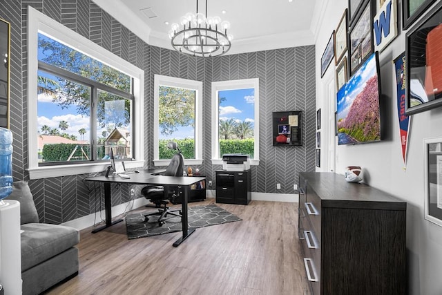 home office with a notable chandelier, ornamental molding, and light hardwood / wood-style floors